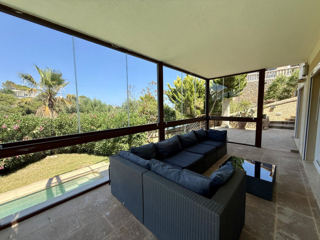 Wintergarten mit vollständig zu öffnender Verglasung und Blick auf die Cala Mandia