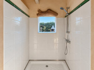 Dusche mit eingelassenem Holzbalken im Gästeapartment - Autarke Finca kaufen an der Ostküste von Mallorca