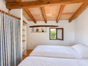 Gemütliches Doppelschlafzimmer mit Holzbalken und Einbauschrank im Gästeapartment der Finca an der Ostküste in Mallorca - Finca kaufen Mallorca